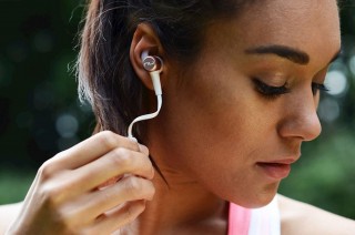 A women wear Optoma NuForce BE Sport3  earphones